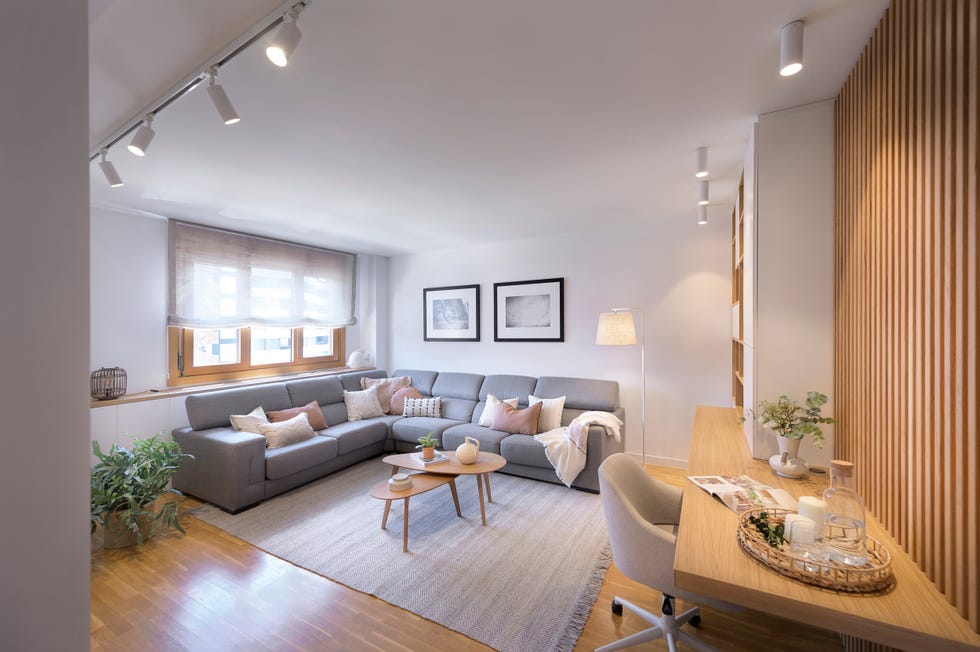 salón con sofá rinconera y escritorio de madera