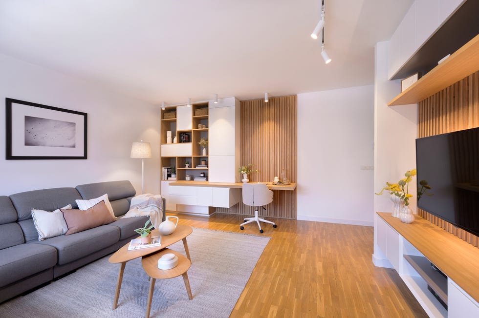salón con sofá rinconera y escritorio de madera
