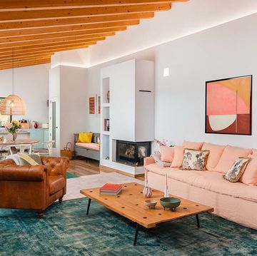 salon rustico con color, chimenea y sofa rosa