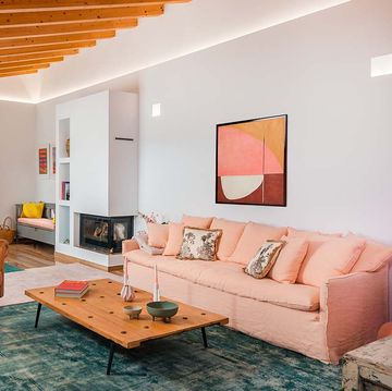 salon rustico con color, chimenea y sofa rosa
