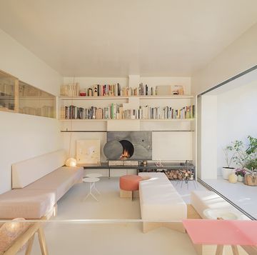 a living room with a fireplace and a shelf with books