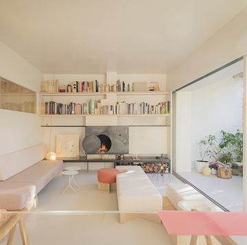 a living room with a fireplace and a shelf with books