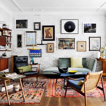 un salon con muebles vintage, sofa verde y cuadros en la pared