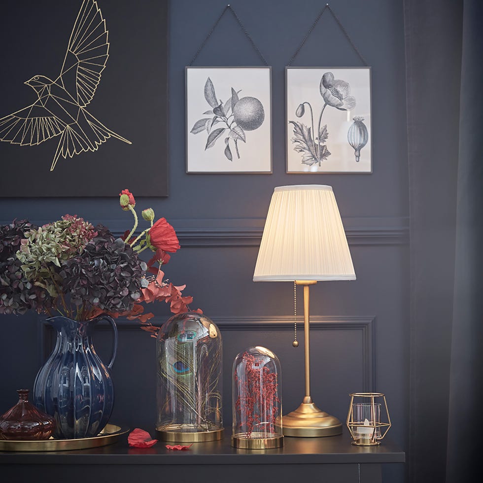 aparador con campanas decorativas y una lámpara de mesa
