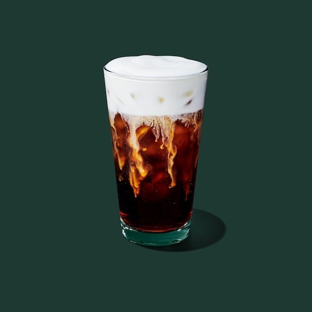 cold brew coffee with foam and ice featuring a light frothy top
