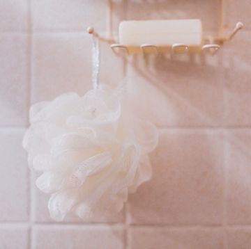 body wash vs bar soap loofah hanging from shower caddy in bathroom bar of soap present conceptual image for showering, bathing, cleanliness and body care