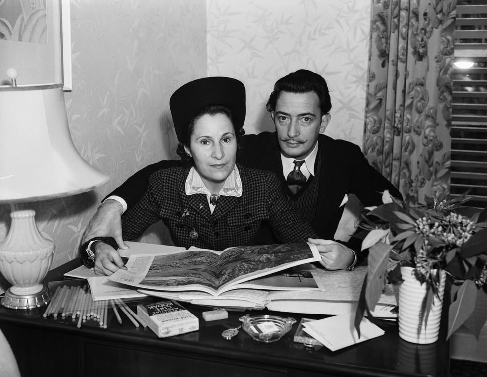 mr and mrs salvador dali examining a book together