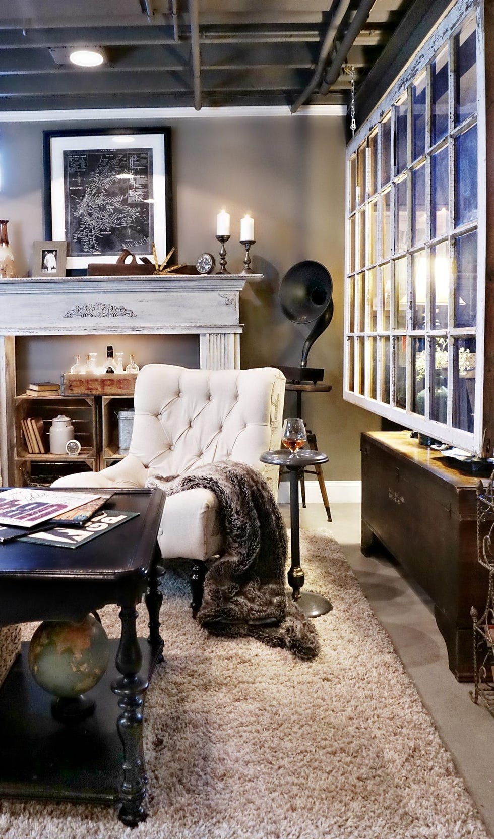 salvaged window with white grilles used as a room divider in a black, white and grey room with vintage decor