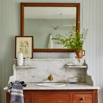 Salway New York Farmhouse Bathroom bathroom vanity with wood cabinets and marble sink and shelf with a mirror above it