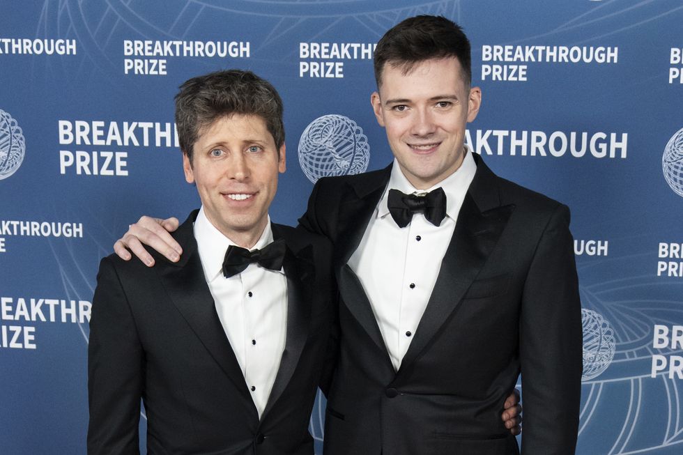 two men wearing tuxedos embracing and smiling