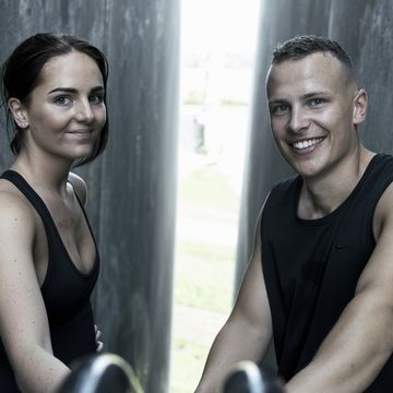 a fit man and fit woman posing for a picture
