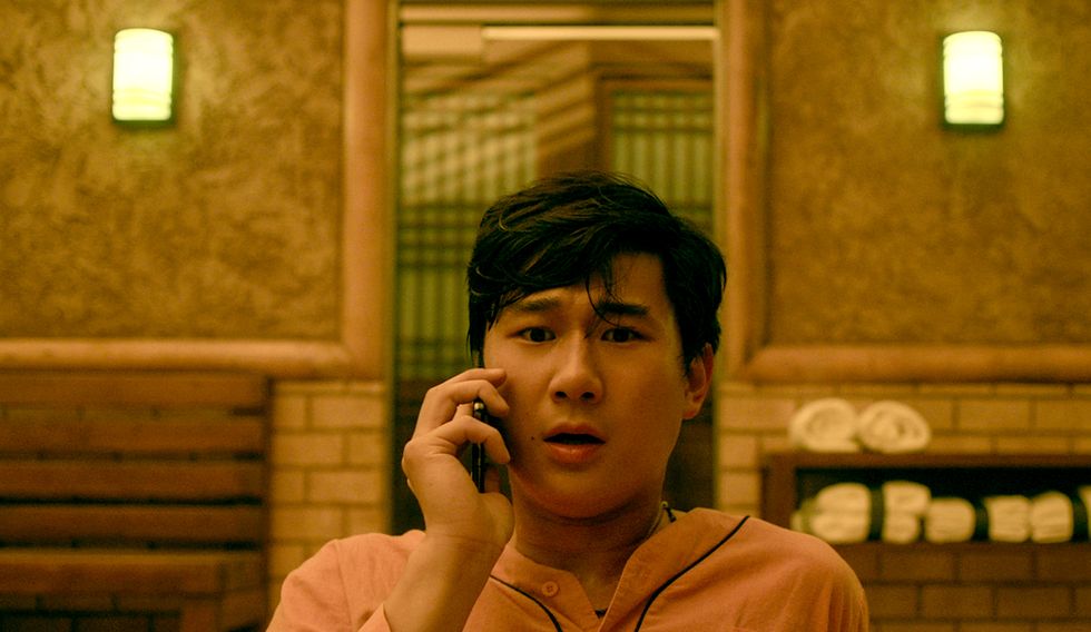Sam Song Li como Bruce Sun hablando por teléfono bajo el sol de los hermanos