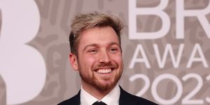 lsam thompson attends the brit awards 2023 at the o2 arena on february 11, 2023 in london, wearing black suit as he smiles on red carpet