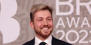 lsam thompson attends the brit awards 2023 at the o2 arena on february 11, 2023 in london, wearing black suit as he smiles on red carpet