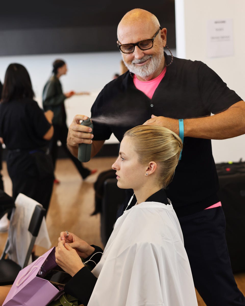 hair stylist applying product to a clients hair during a styling session