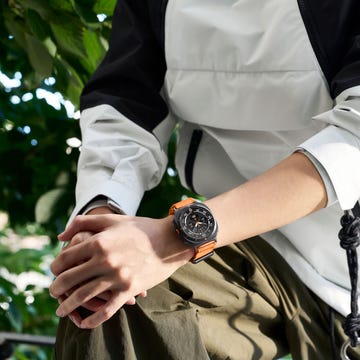 wristwatch on a persons arm complemented by a stylish outerwear