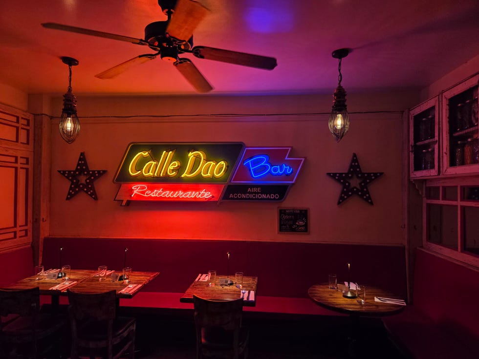 inside of a restaurant lit by neon signs