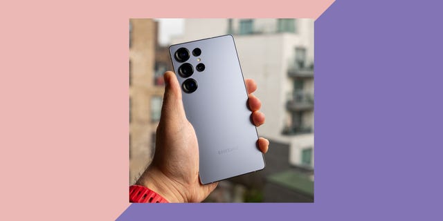 smartphone being held in hand against an urban backdrop