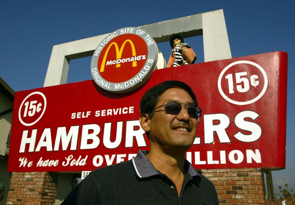 San Bernardino. Nov. 23, 2004. Albert Okura (cq), left, stands under the sign of McDonal's at h San Bernardino. Nov. 23, 2004. Albert Okura (cq), left, stands under the sign of McDonal's at h