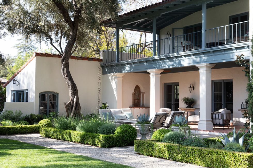san gabriel valley california home period appropriate boxwood hedges outline the back garden where potted agave adds mediterranean flavor the outdoor furnishings were selected by madeline stuart associates