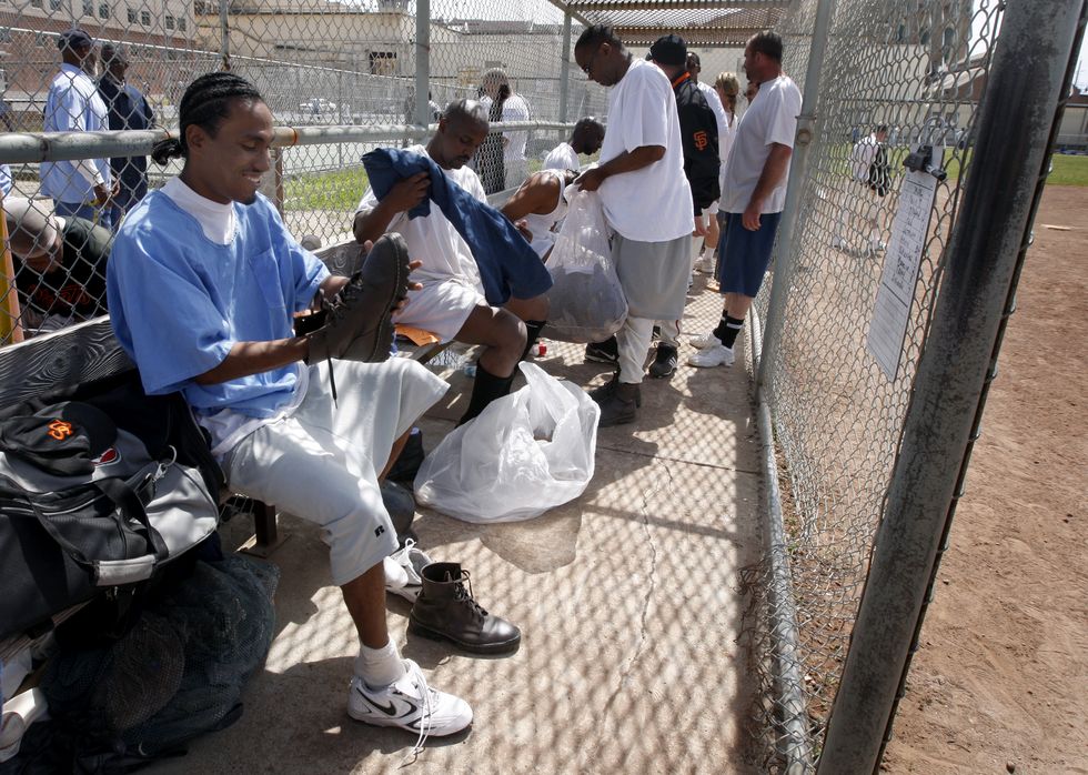 san quentin giants player dominique oden (left) and his teammates change back into their prison outfits after the opening day baseball game in san quentin on saturday