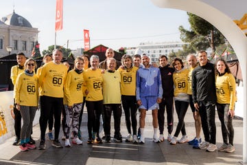 Group of runners in yellow shirts posing for a photo at an event