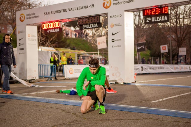 un hombre se arrodilla a su llegada a la meta de la san silvestre vallecana 2019