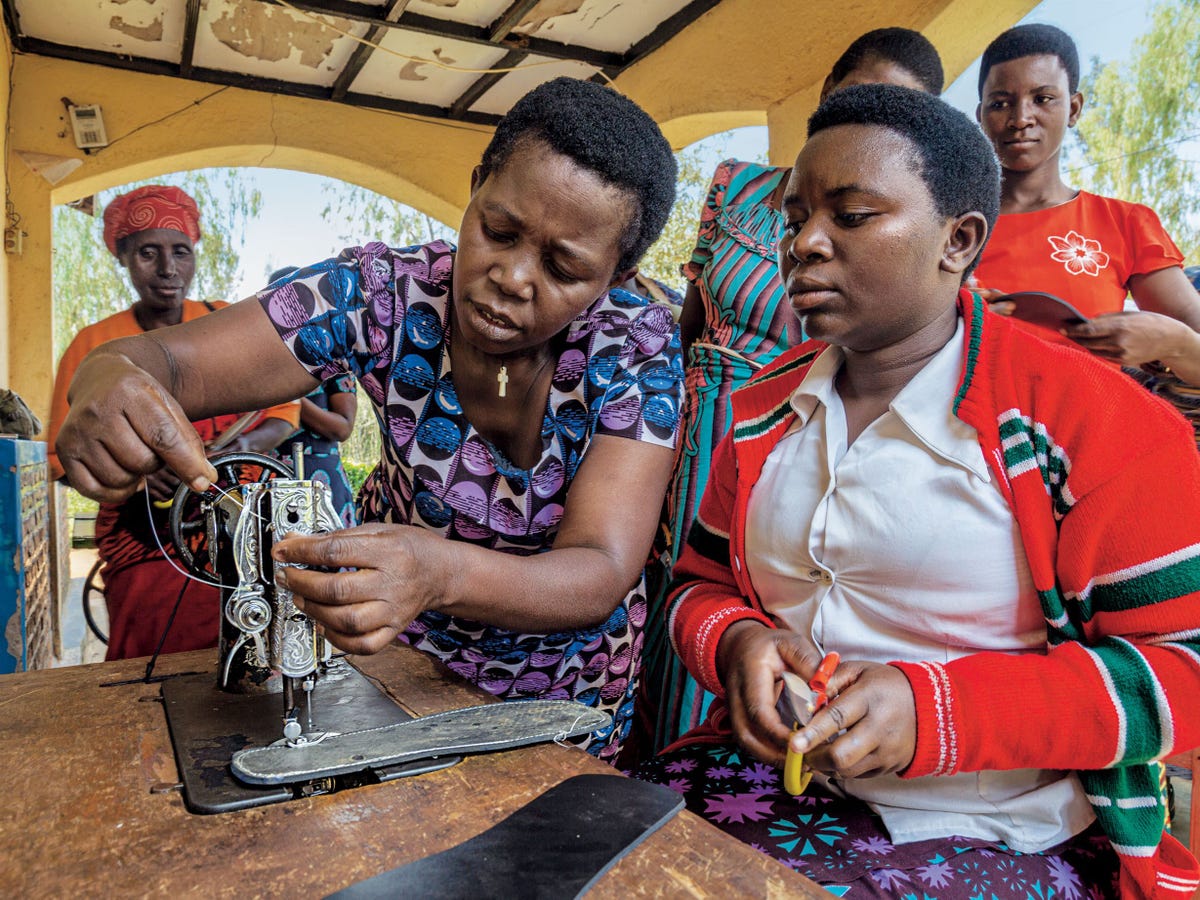 Nyirabizeyimana Immaculee rechts leert sandalen maken in het oostelijke district Mugesera Het Rwanda Womens Network biedt vrouwen plekken waar ze veilig kunnen samenzijn en beroeps vaardigheden leren