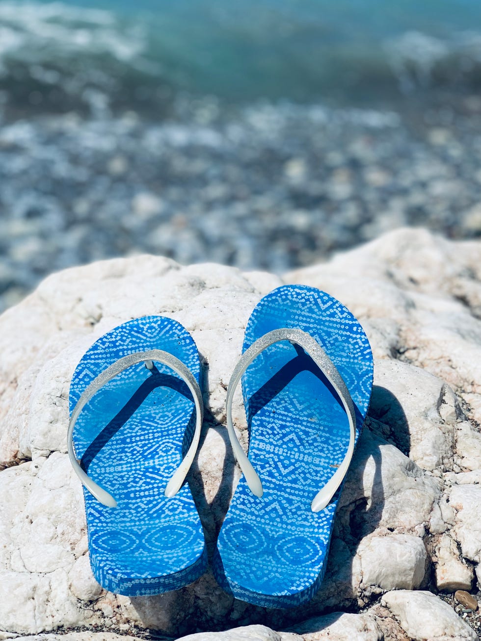 sandals or flip flops on the stone beach on sea background