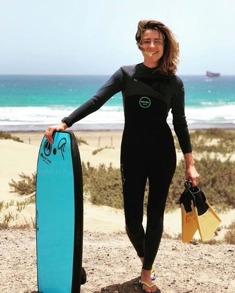 Wetsuit, Surfing Equipment, Personal protective equipment, Surfboard, Surfing, Bodyboarding, Standing, Surface water sports, Boardsport, Surfer hair, 