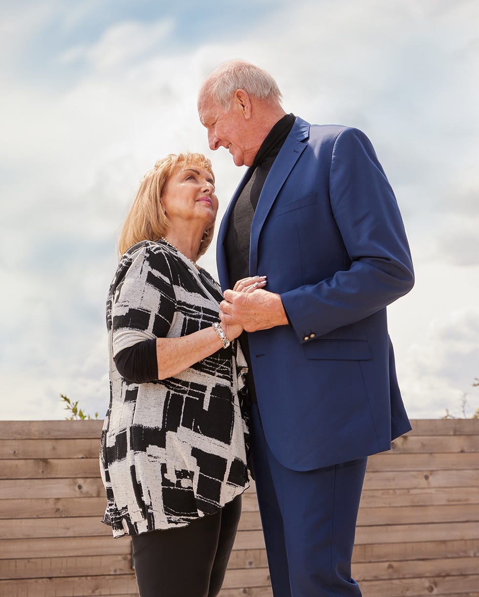 two people standing close together holding hands