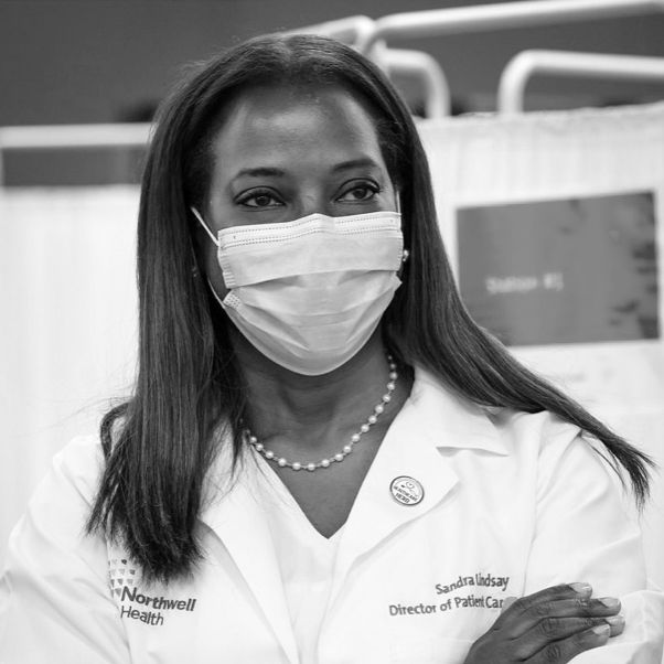 sandra lindsay wearing a white coat and blue surgical mask