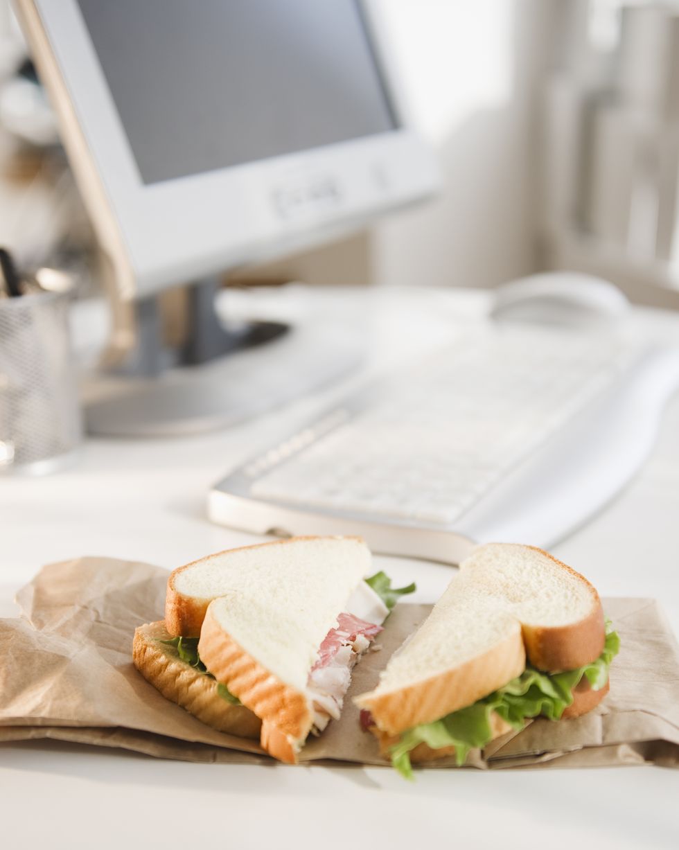 sandwich on brown bag beside computer