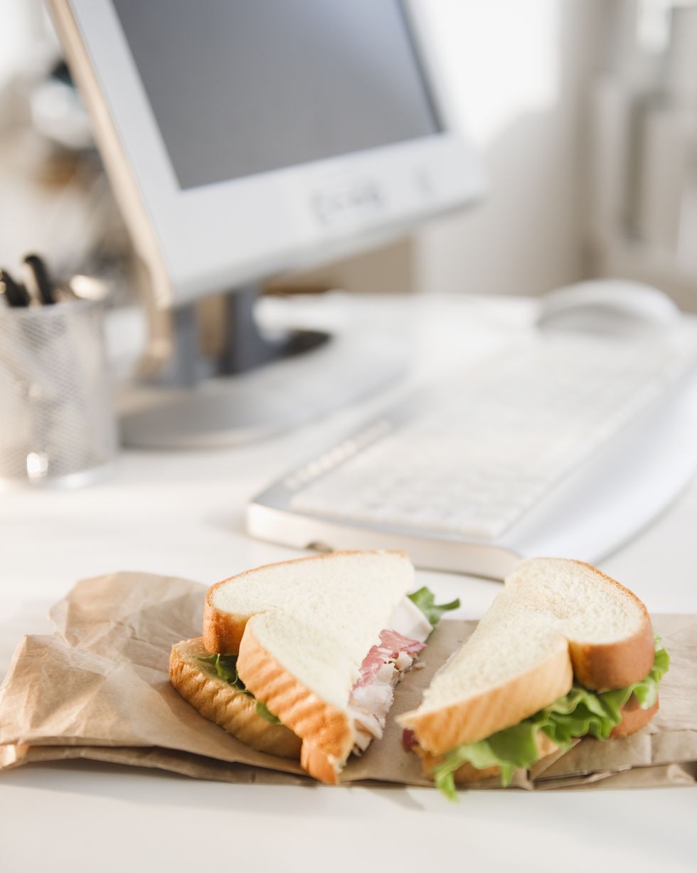 sandwich on brown bag beside computer
