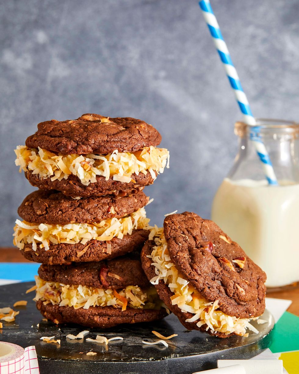 three german chocolate sandwich cookies stacked on top of each other with one more sandwich cookie leaning against them