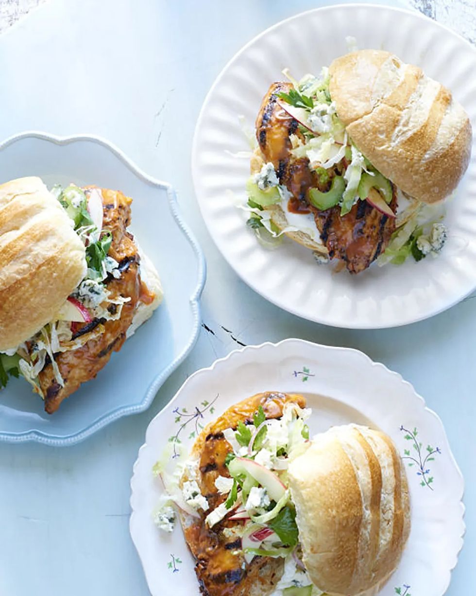 three grilled buffalo chicken sandwiches on white plates