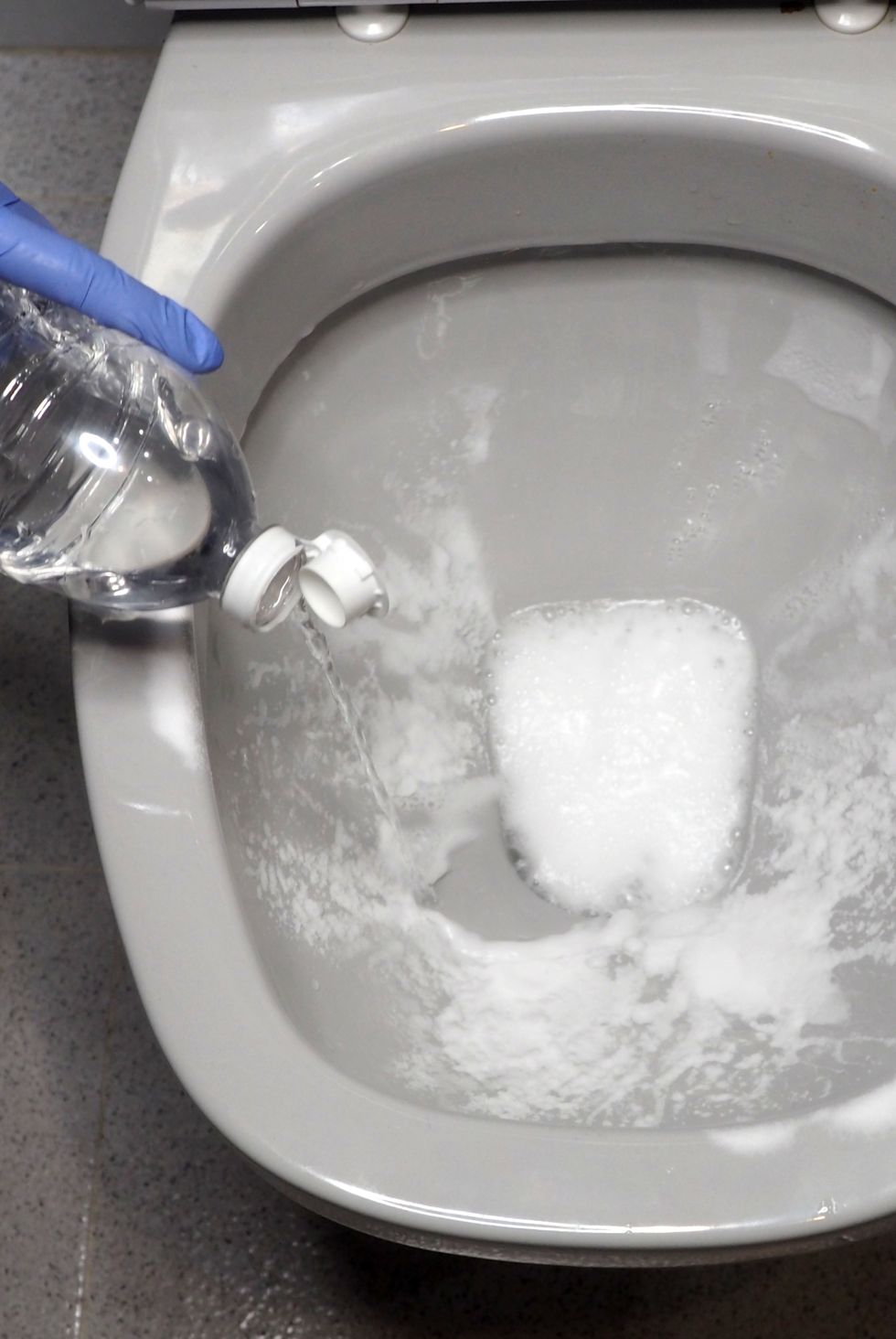 sanitizing the toilet bowl with baking soda and vinegar