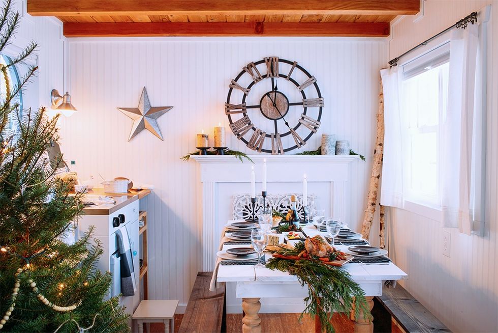 small rustic white kitchen with beadboard walls, table for 6 with bench seating, christmas tree