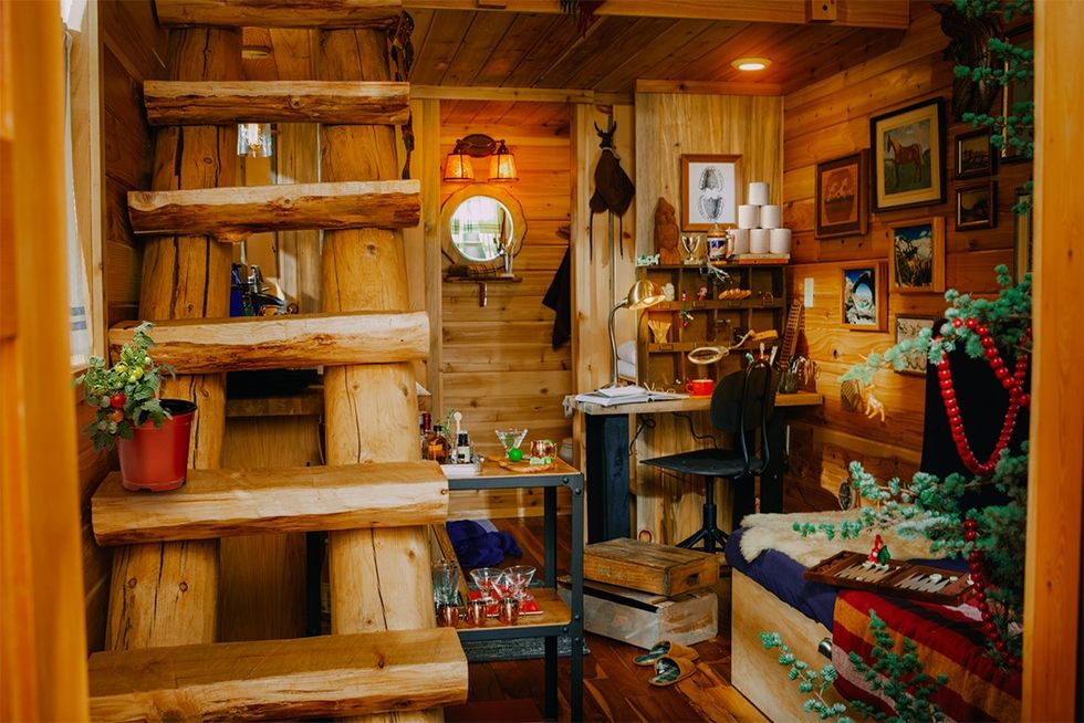 interior view of elf log cabin with rough hewn stairs to second floor
