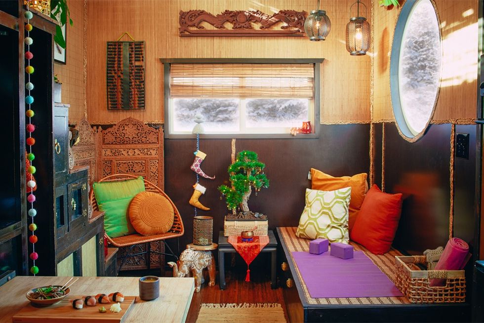 tiny house living area with asian and indian design influences, including wood carvings, bonsai, and yoga area
