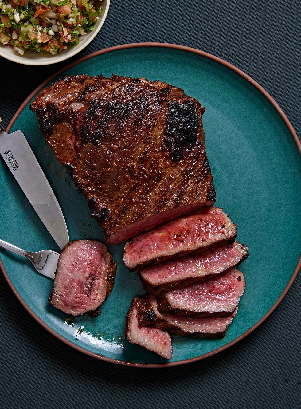 sliced santa maria tri tip steak on a teal plate