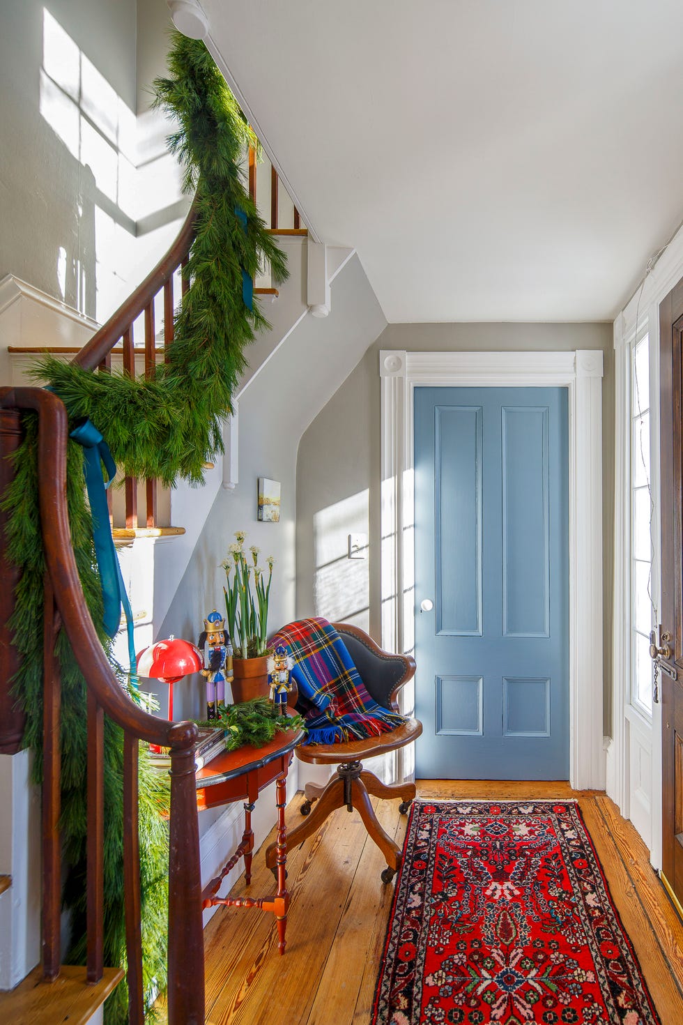christmas foyer entryway with garland and bows