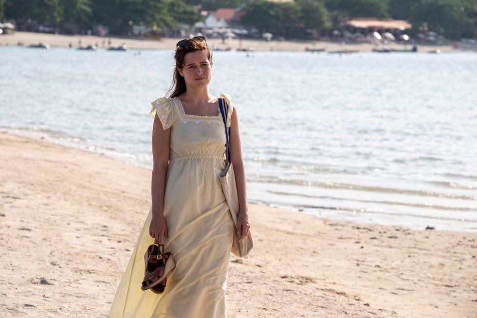 woman in a yellow dress walking along the beach