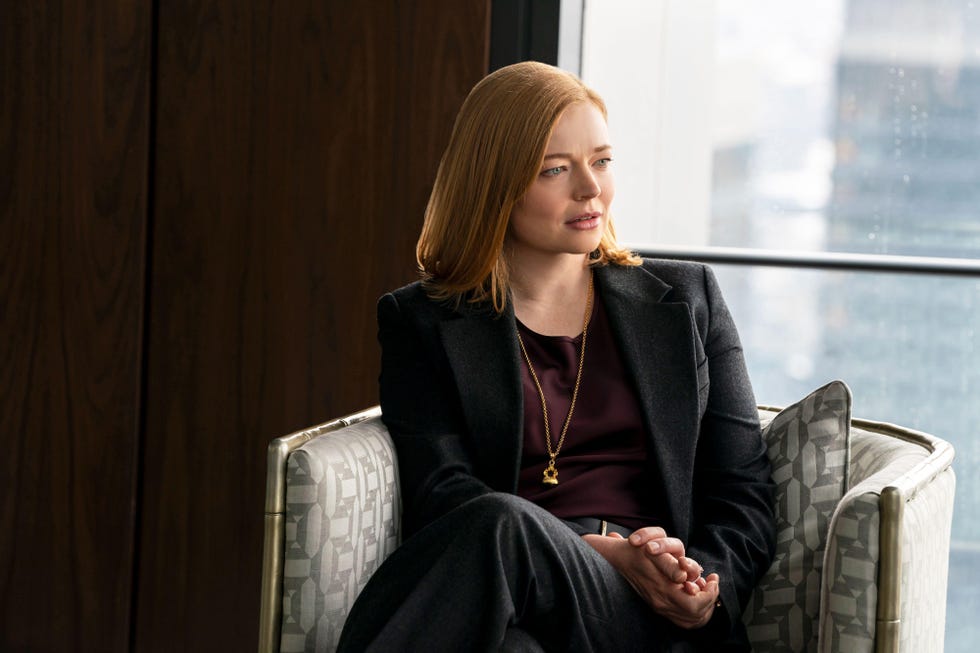 a woman in a suit sitting in an office environment
