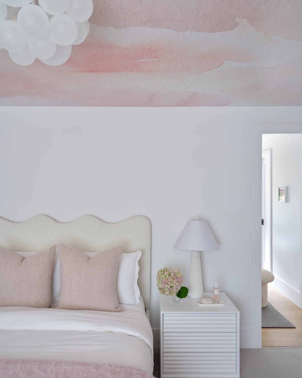 bedroom with pink wallpaper ceiling and pillows