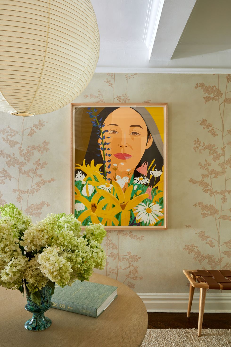 framed portrait of a woman and flowers on a floral wall