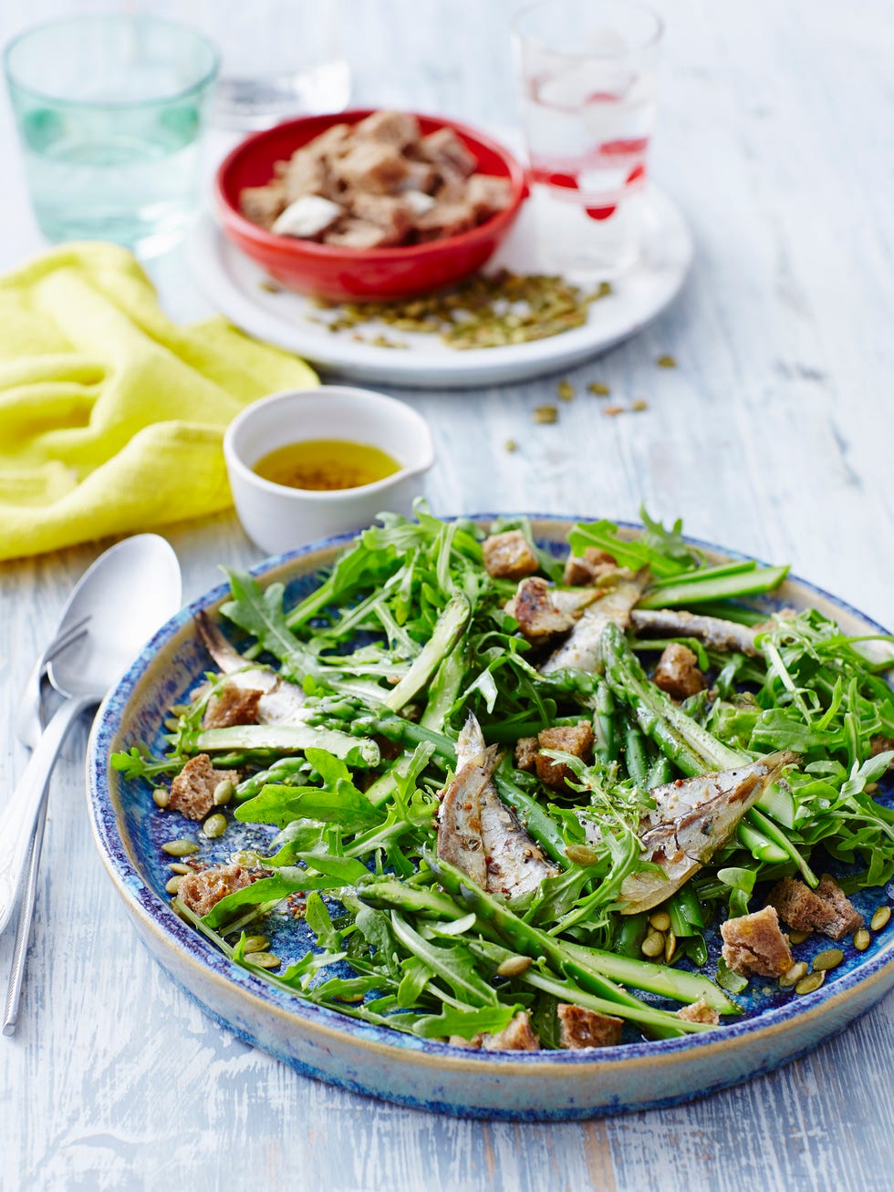 sardines and salad greens on a blue plate