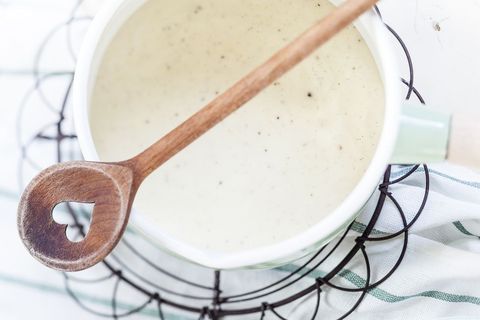 Saucepan of homemade vanilla custard and cooking spoon