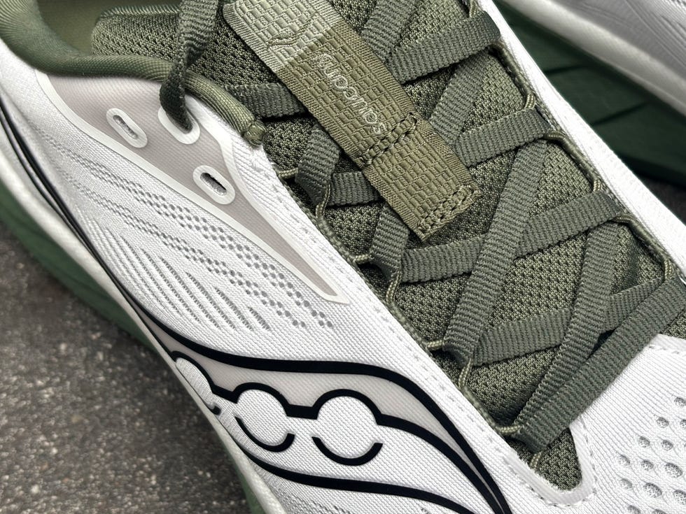 athletic shoe featuring a white and olive green color scheme