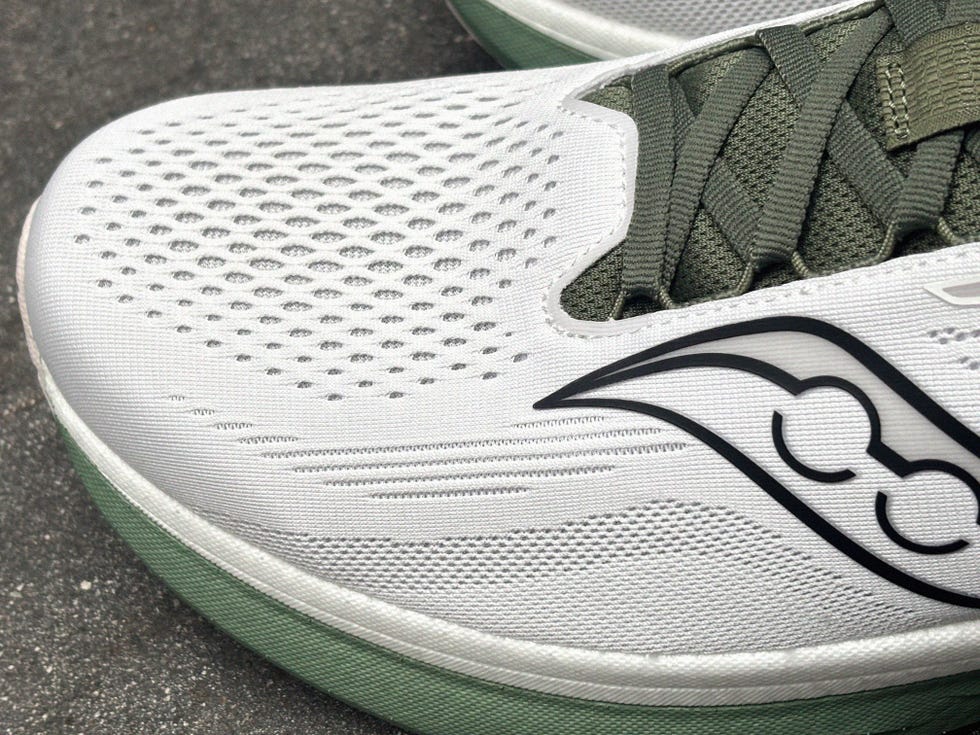 closeup of a white and green athletic shoe with a recognizable logo